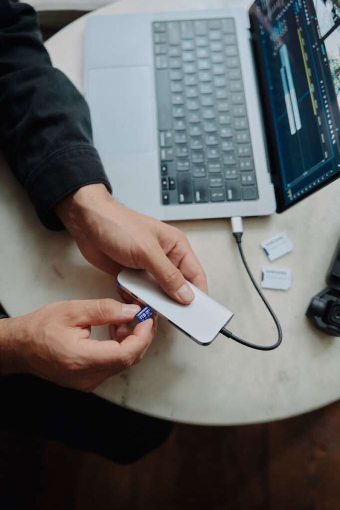 A person sitting at a table with a laptop and a mouse