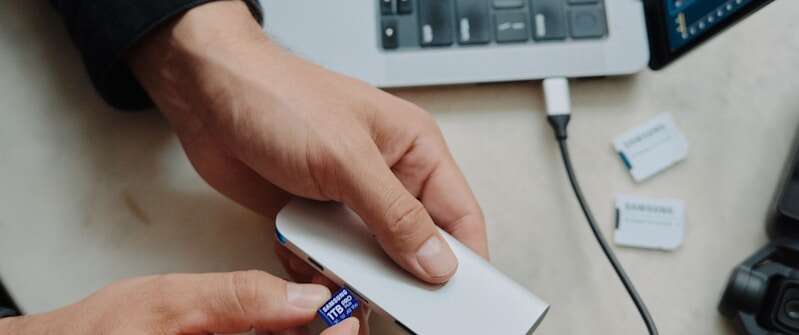 A person sitting at a table with a laptop and a mouse